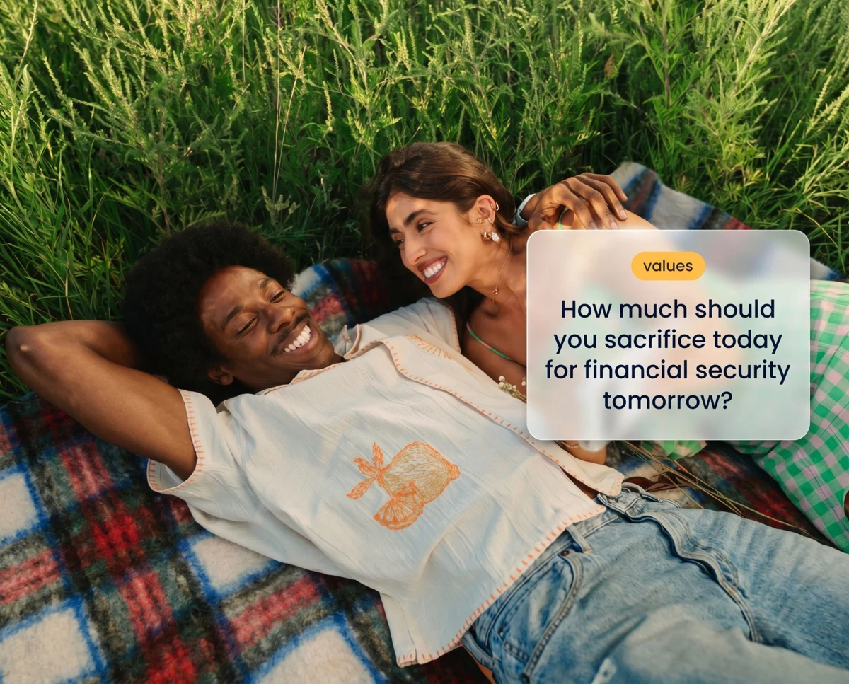A couple lying on a picnic blanket, laughing over a Pick One money question